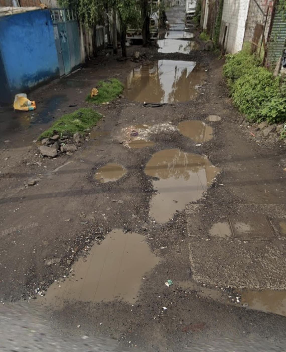 Vía pública con múltiples baches inundados